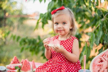 Şirin çocuk yazın sulu karpuz yiyor. Çocuk, bebek, çocuklar için sağlıklı yiyecek. Limonata satmaya çalışan sevimli küçük kız. Buzlu ve naneli karpuz limonatası.