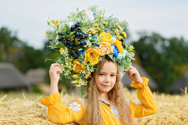 Girl in traditional ukrainian wreath on head blue and yellow flag of Ukraine in field. Ukraine's Independence Flag Day. Constitution day. 24 August. Patriotic holiday.