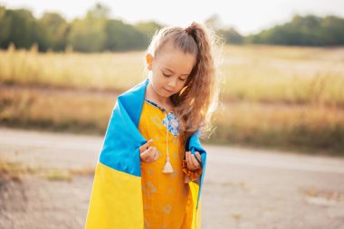 Ukrayna 'nın Bağımsızlık Bayrağı Günü. Anayasa günü. Kız, Ukrayna 'nın dalgalanan mavi ve sarı bayrağını tarlada taşıyor. 24 Ağustos. Vatansever bayram.