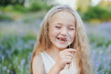 İki ön dişi olmadan beyaz dişlerini gösteren gülümseyen güzel sarışın beyaz kızın portresini yakından çek. Neşeli çocuk..