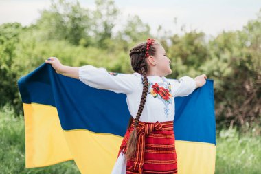 Vyshyvanka Günü. Çocuk, Ukrayna 'nın mavi ve sarı bayrağıyla geleneksel nakış işliyor. Ukrayna Anayasa Günü. 24 Ağustos. Vatansever bayram. Bir kızın açık hava portresi. Ukrayna 'nın Bağımsızlık Günü.
