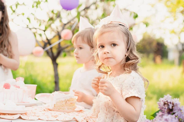 아름다운 정원에 케이크에 촛불을 밝히고 아이들은 분홍색 케익을 먹습니다 야외에서 — 스톡 사진