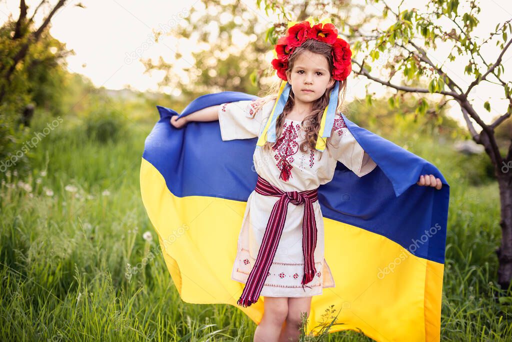 Ukraine's Independence Flag Day. Constitution day. Ukrainian child girl in embroidered shirt vyshyvanka with yellow and blue flag of Ukraine in field. flag symbols of Ukraine. Kyiv, Kiev day