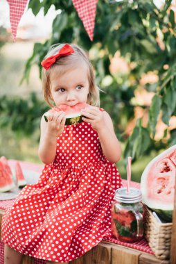 Şirin çocuk yazın sulu karpuz yiyor. Çocuk, bebek, çocuklar için sağlıklı yiyecek. Limonata satmaya çalışan sevimli küçük kız. Buzlu ve naneli karpuz limonatası.