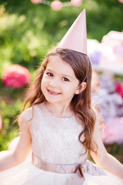 美しい庭にギフトボックス付きの幸せな誕生日の女の子 子供は幸せな誕生日のローズカップケーキを食べる カラフルなパステル装飾屋外 夏の日にパーティーを楽しむ4歳の子供 — ストック写真