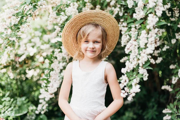 白いドレスと帽子を身に着けているかなり小さな女の子の夏の肖像画 バラの庭の香りの花にポーズ 幸せな笑顔の赤ちゃん 自然の愛 ロマンチックな気分 — ストック写真