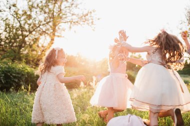 Bir grup çocuk oyun bahçesinde sabun köpüğü oynuyor. Günbatımı geçmişi, çocuk, çocuk, okul, oyun ve yaz geçmişi var. Mutlu çocukluk