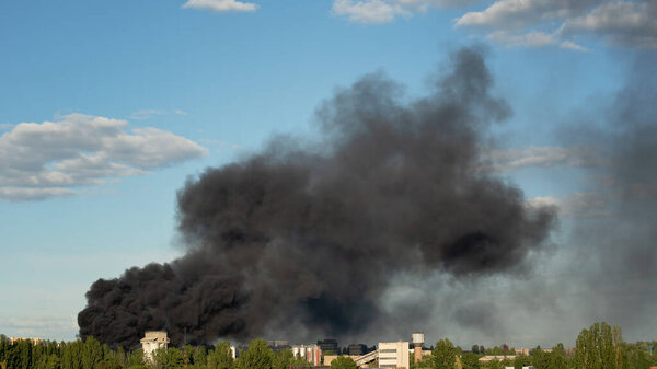 Burning building with black smoke. factory fire burning. Huge smoke clouds after explosion. Technogenic accident