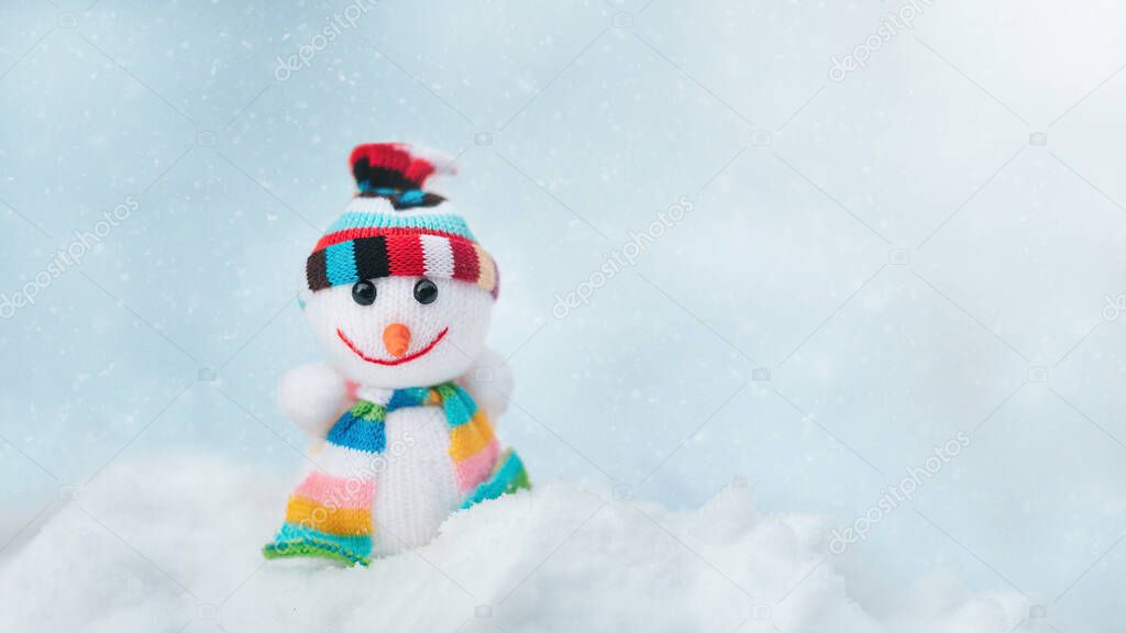 Merry christmas and happy new year greeting card with copy space. Happy Toy of snowman in cap and scarf standing in winter snow background. christmas fairytale.