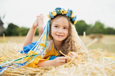 Ukrayna 'nın mavi ve sarı bayrağı üzerinde geleneksel Ukrayna çelenginde bir kız. Ukrayna 'nın Bağımsızlık Bayrağı Günü. Anayasa günü. 24 Ağustos. Vatansever bayram.