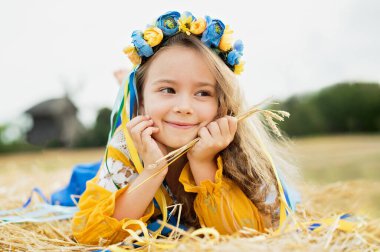 Ukrayna 'nın mavi ve sarı bayrağı üzerinde geleneksel Ukrayna çelenginde bir kız. Ukrayna 'nın Bağımsızlık Bayrağı Günü. Anayasa günü. 24 Ağustos. Vatansever bayram.