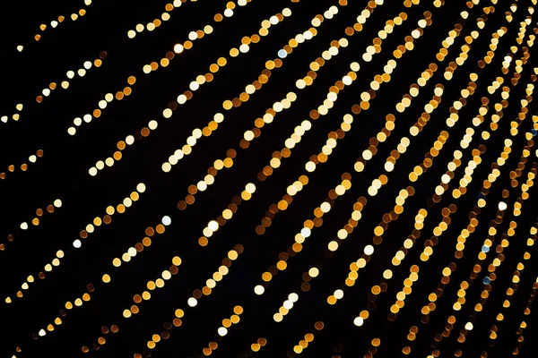 光のボケが背景に集中している クリスマスライトの燃えるような写真 黄金の光の効果 休日背景照明のコンセプト — ストック写真
