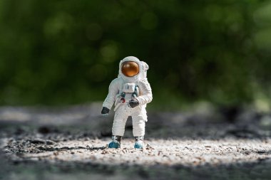 Oyuncak astronot yerde duruyor. Uzay adamı figürü seyahat konsepti çevre koruması. Astronot yeni gezegeni keşfediyor. İnsanlık için yeni bir yuva arıyorum. Bilim ve doğa kavramları