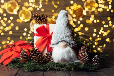 Mutlu noeller. Gnome 'lu Noel kompozisyonu ve ahşap arka planda şenlikli dekorasyonlar. Noel ya da yeni yıl tebrik kartı. Noel cücesi geçmişi. Noel sembolü. İyi tatiller..