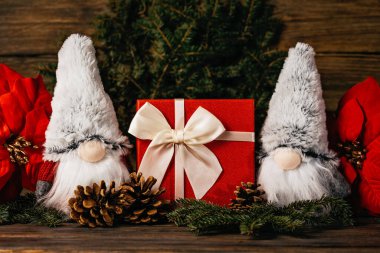 Mutlu noeller. Gnome 'lu Noel kompozisyonu ve ahşap arka planda şenlikli dekorasyonlar. Noel ya da yeni yıl tebrik kartı. Noel cücesi geçmişi. Noel sembolü. İyi tatiller..