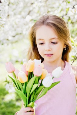Etrafı çiçek açan beyaz kiraz çiçekleriyle çevrili genç kız aşkı, aile bağını ve baharda anneler gününü sembolize ediyor. Ilık bahar selamları