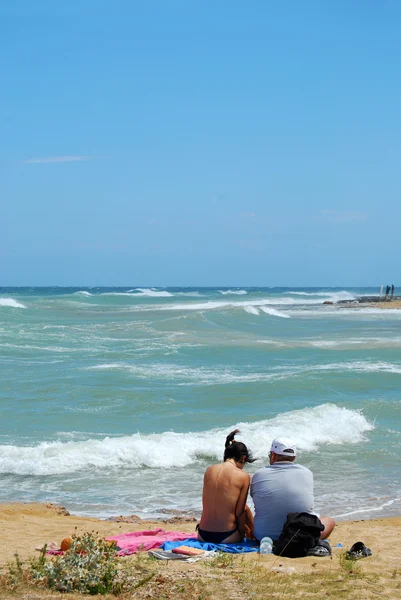 Egy pár turista a strandon, söpörte a Mistral - Apulia — Stock Fotó