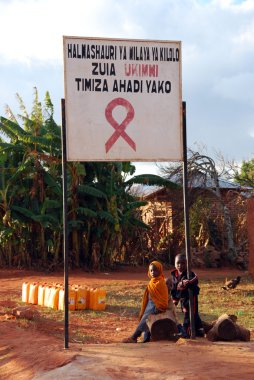 Bazı çocuklar AIDS bölge pomerini, Tanzanya, Afrika köyün girişinde işaret altında