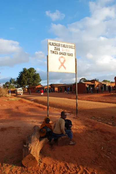 Některé děti ve znamení aids zóny u vchodu do vesnice pomerini Tanzanie Afrika — Stock fotografie