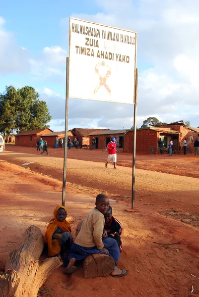 Bazı çocuklar AIDS bölge pomerini, Tanzanya, Afrika köyün girişinde işaret altında
