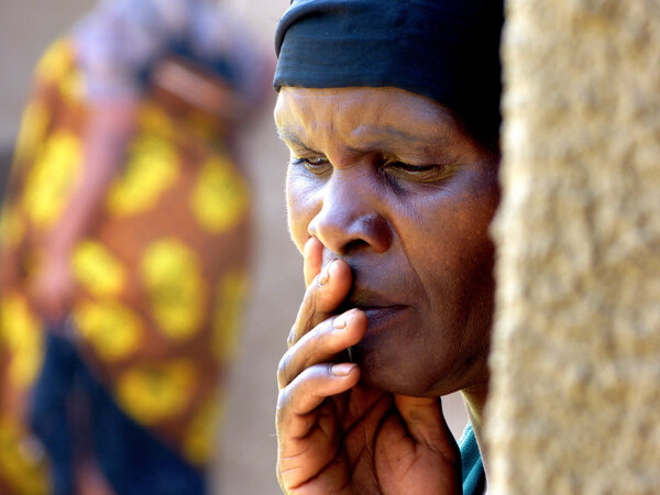 Лицо пожилой африканской женщины гружено мыслями и скрыто
