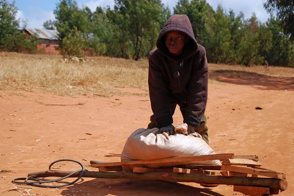 Een Afrikaans kind om te werken met zijn kruiwagen — Stockfoto