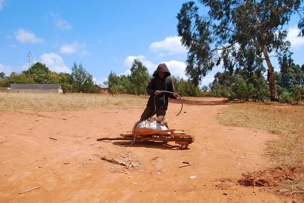 Ein afrikanisches Kind zur Arbeit mit der Schubkarre — Stockfoto