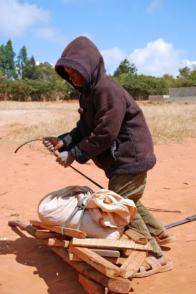 Un bambino africano al lavoro con la carriola — Foto Stock