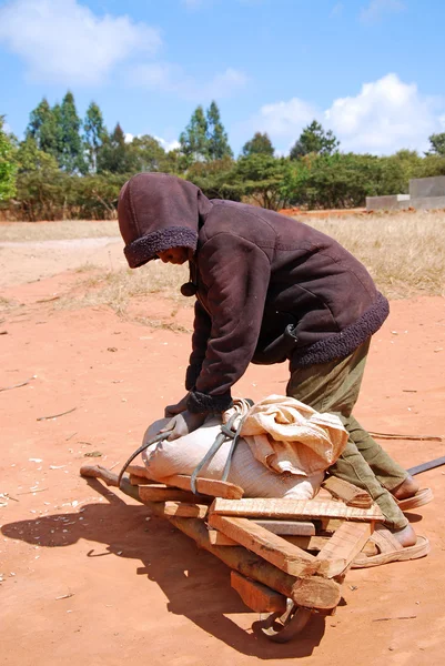 Jedno afrykańskie dziecko do pracy z jego taczki — Zdjęcie stockowe