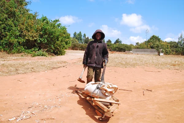 Un niño africano para trabajar con su carretilla — Foto de Stock