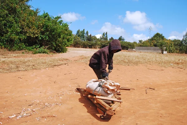 Ein afrikanisches Kind zur Arbeit mit der Schubkarre — Stockfoto