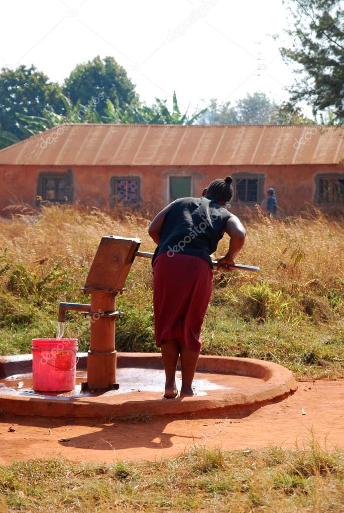 A woman and pump water from a public fountain-Pomerini-Tanzania-