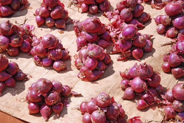 Tentoonstelling en verkoop tot in het detail van rode uien op de markt van — Stockfoto