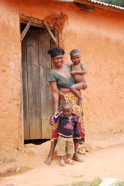 Una mujer africana no identificada con sus hijos en la puerta —  Fotos de Stock