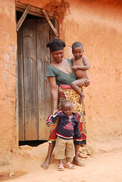 Una mujer africana no identificada con sus hijos en la puerta —  Fotos de Stock