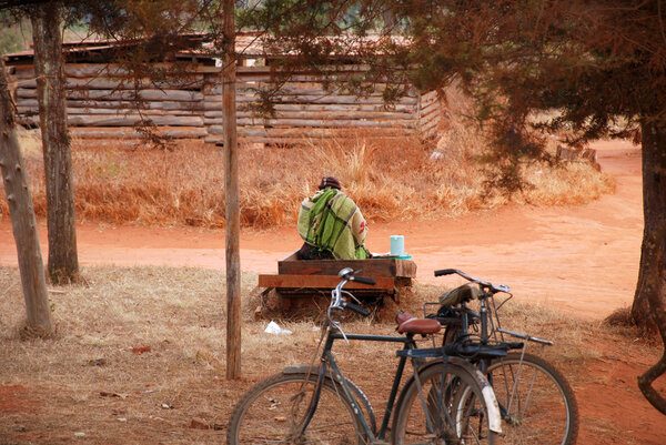 A woman sitting on a street sells a drink, Pomerini, Tanzania, A