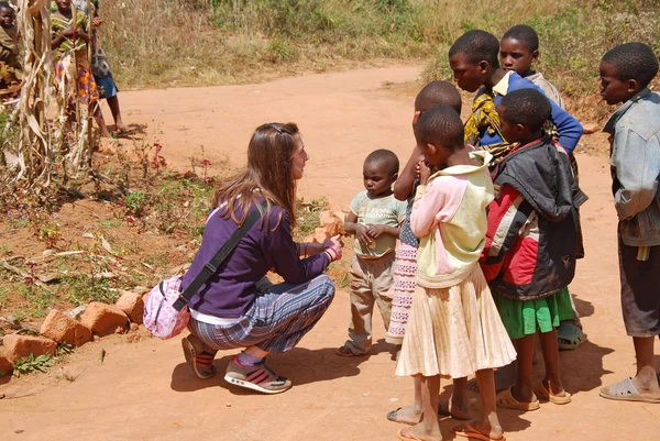 Une femme médecin bénévole parle avec des enfants africains 60 — Photo