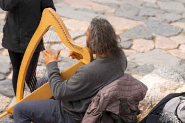 Street Musician Playing Classical Harp clipart