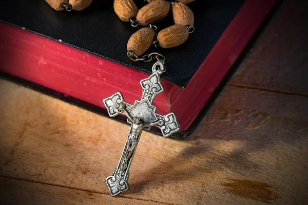 Różańcem i Pismo Święte na drewnianym stole — Zdjęcie stockowe