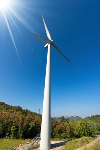 Turbina wiatrowa w góry z promieni słonecznych — Zdjęcie stockowe