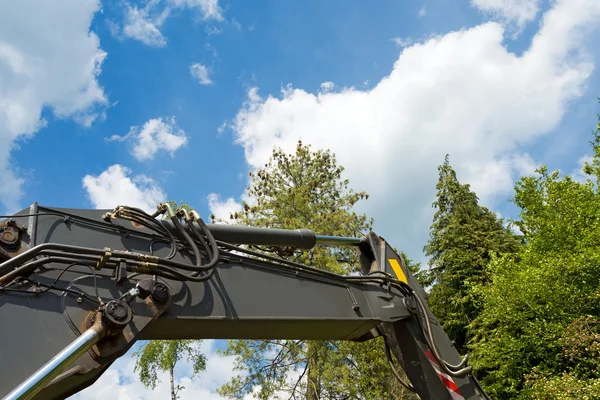 Grävmaskinens Arm med träd och blå himmel — Stockfoto