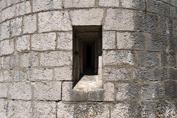 Серая крепостная стена с лазейкой — стоковое фото