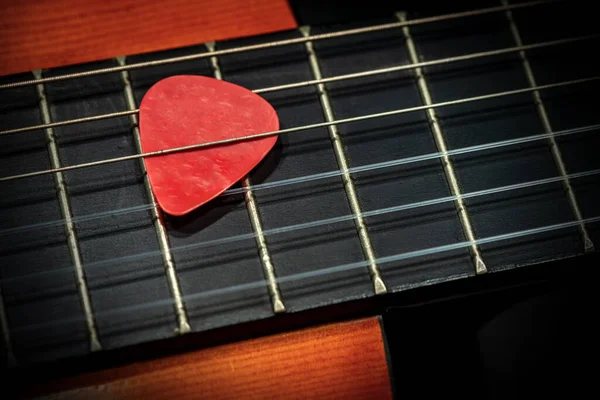 Kırmızı Bir Gitar Penasının Plectrum Eski Bir Akustik Gitarın Fretboard — Stok fotoğraf