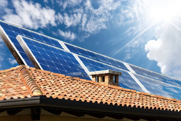 Zonnepanelen Boven Het Dak Van Een Huis Aan Blauwe Hemel Stockafbeelding