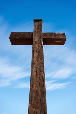 Açık mavi gökyüzünde, bulutlu ve kopya uzayı olan ahşap bir Hristiyan haçı. Garda, Verona, Veneto, İtalya, Avrupa.