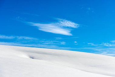 Mavi gökyüzünde toz kar ve bulutlarla kaplı bir kış manzarasına yakın. Lessinia Plateau (Altopiano della Lessinia), Regional Natural Park, Verona Eyaleti, Veneto, İtalya, Avrupa