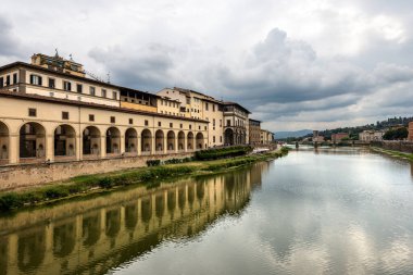 Floransa. Arno Nehri manzaralı Ortaçağ Ponte Vecchio (Eski Köprü). Soldaki Vasari Koridoru (Corridoio Vasariano, 1565) Palazzo Vecchio 'yu Pitti Sarayı' na bağlar. Toskana İtalya.