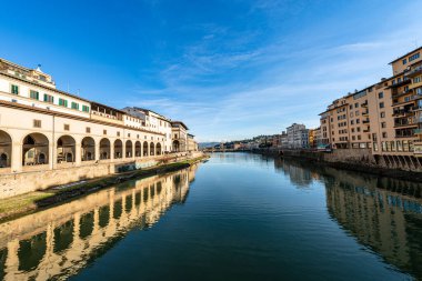 Floransa. Arno Nehri manzaralı Ortaçağ Ponte Vecchio (Eski Köprü). Soldaki Vasari Koridoru (Corridoio Vasariano, 1565) Palazzo Vecchio 'yu Pitti Sarayı' na bağlar. Toskana İtalya.
