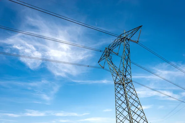 高電圧タワーの写真 雲とコピースペースと青い空に対する電気ケーブルと絶縁体と電源ライン — ストック写真