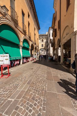 MANTUA, İtalya - 9 Mayıs 2021: Mantua Downtown, Via Broletto, Lombardy, İtalya, Avrupa 'daki restoranlar ve pizzacılar. Birçok insan tarihi merkezde, caddenin atari salonlarının altında öğle yemeği yiyor..